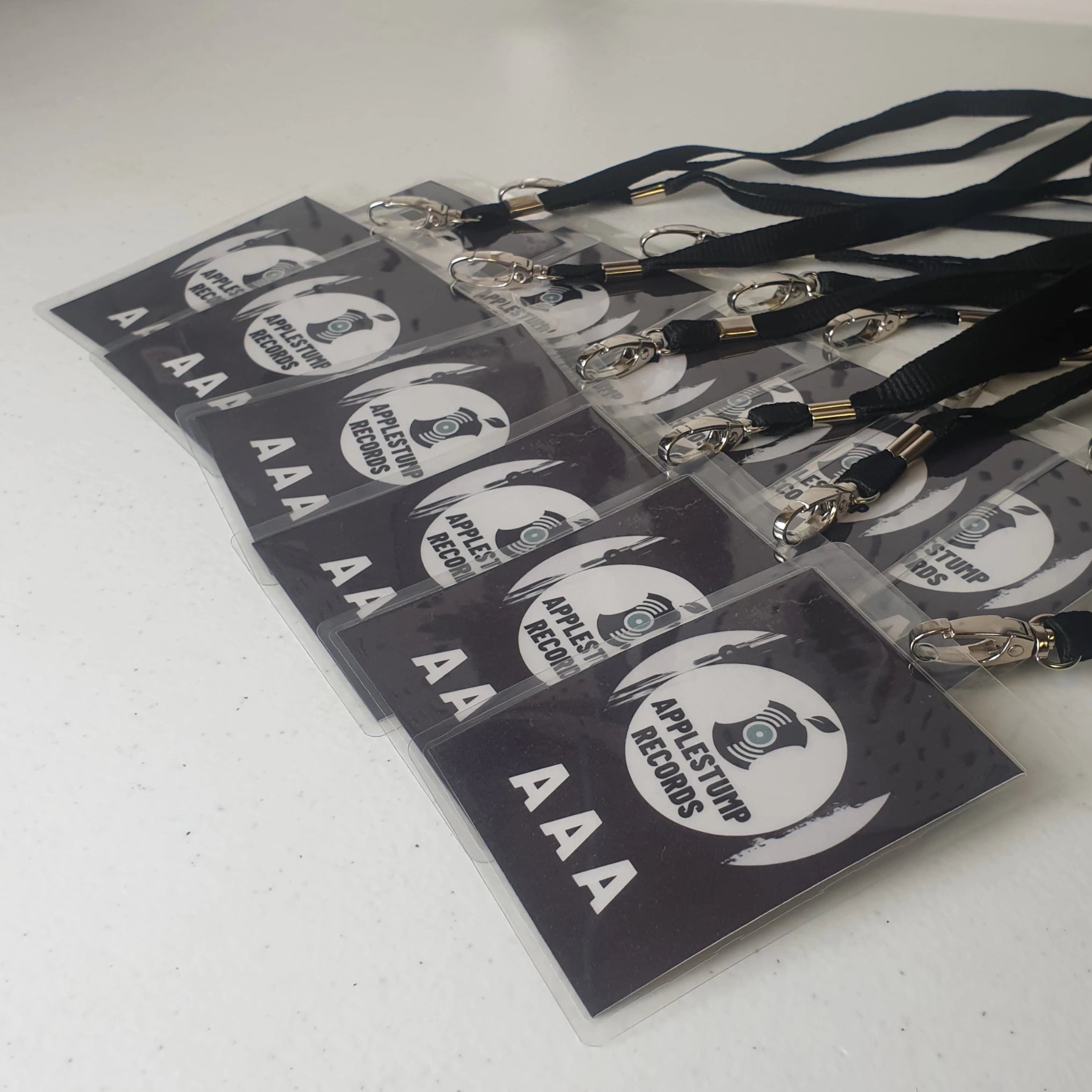 Black custom AAA event passes for Applestump Records with black lanyards.