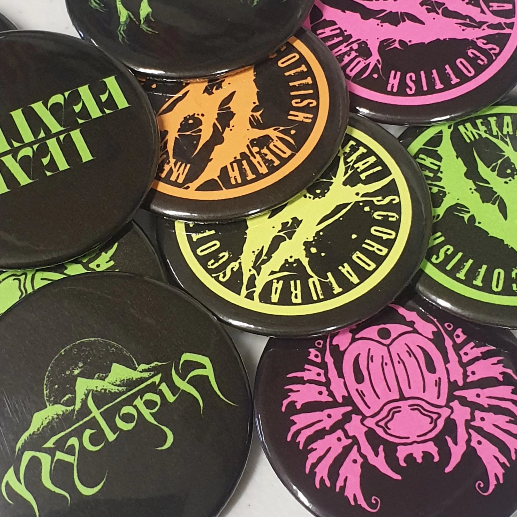 collection of custom neon pocket mirrors with band logos on them.