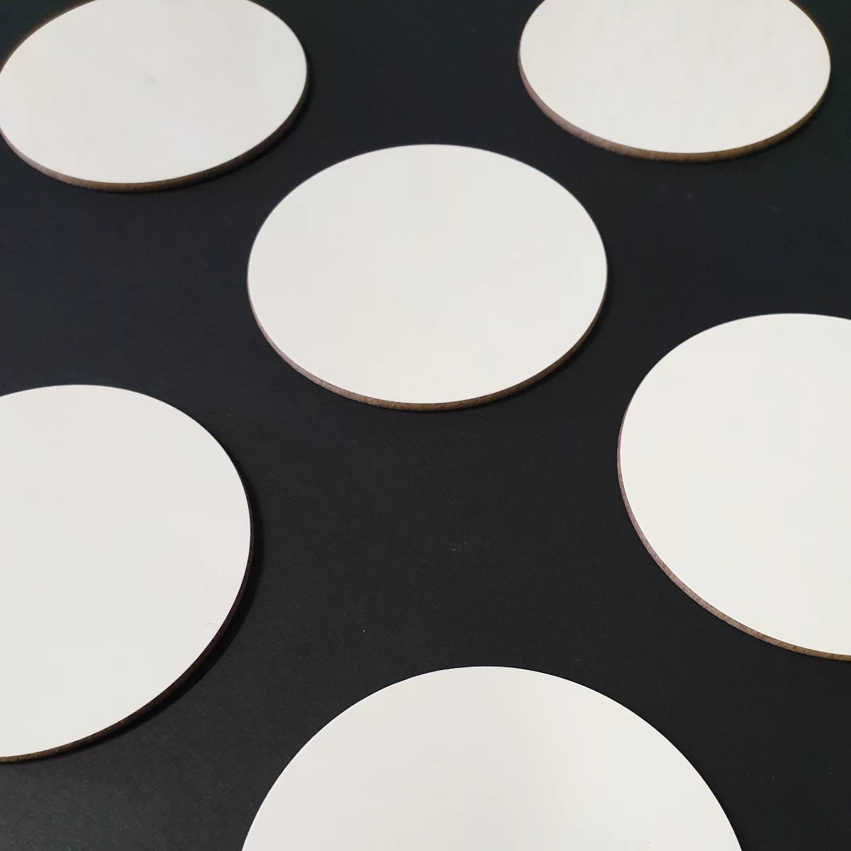 Custom 9cm circular coasters, ready for customisation with artwork and logos.
