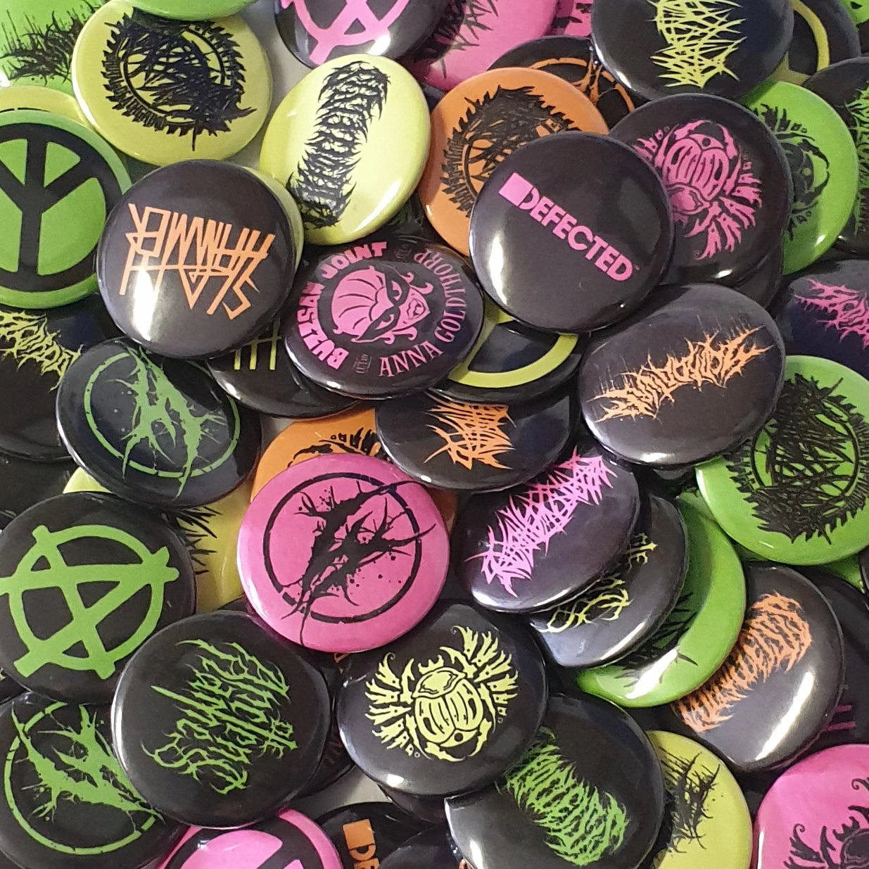 Collection of colorful buttons with various designs and text.