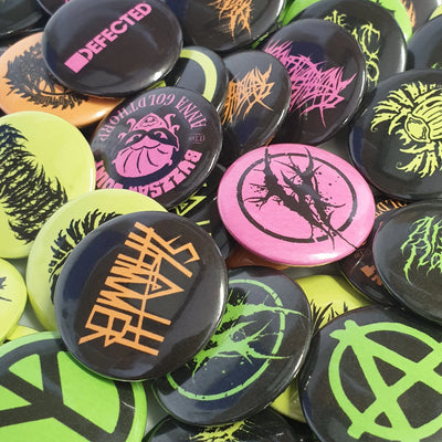 Collection of colorful buttons with various designs and text.