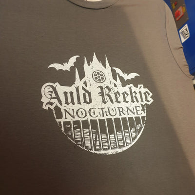 Gray t-shirt with a white graphic design featuring text and castle-like structure.