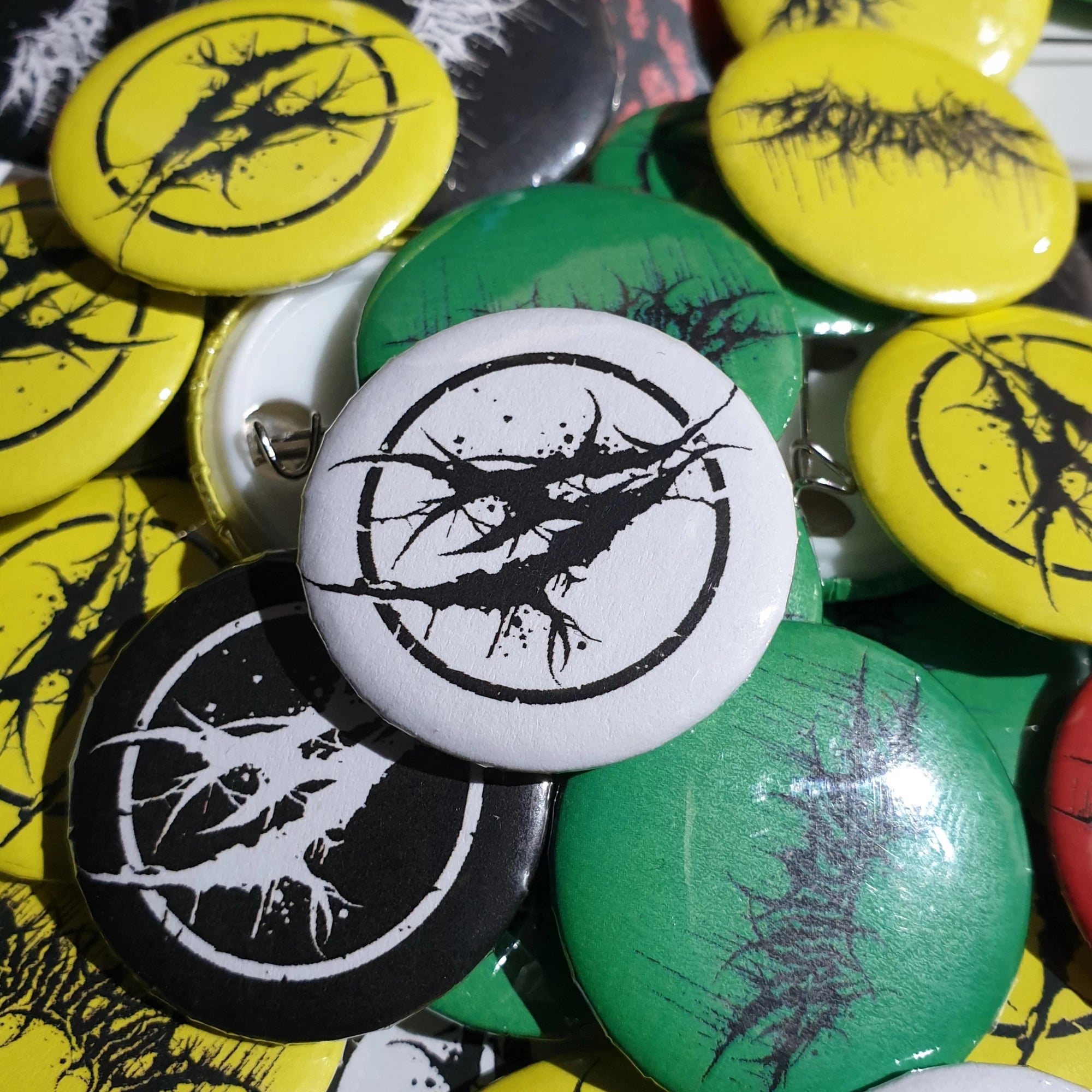 Collection of badges with band logo design on various colored badges.