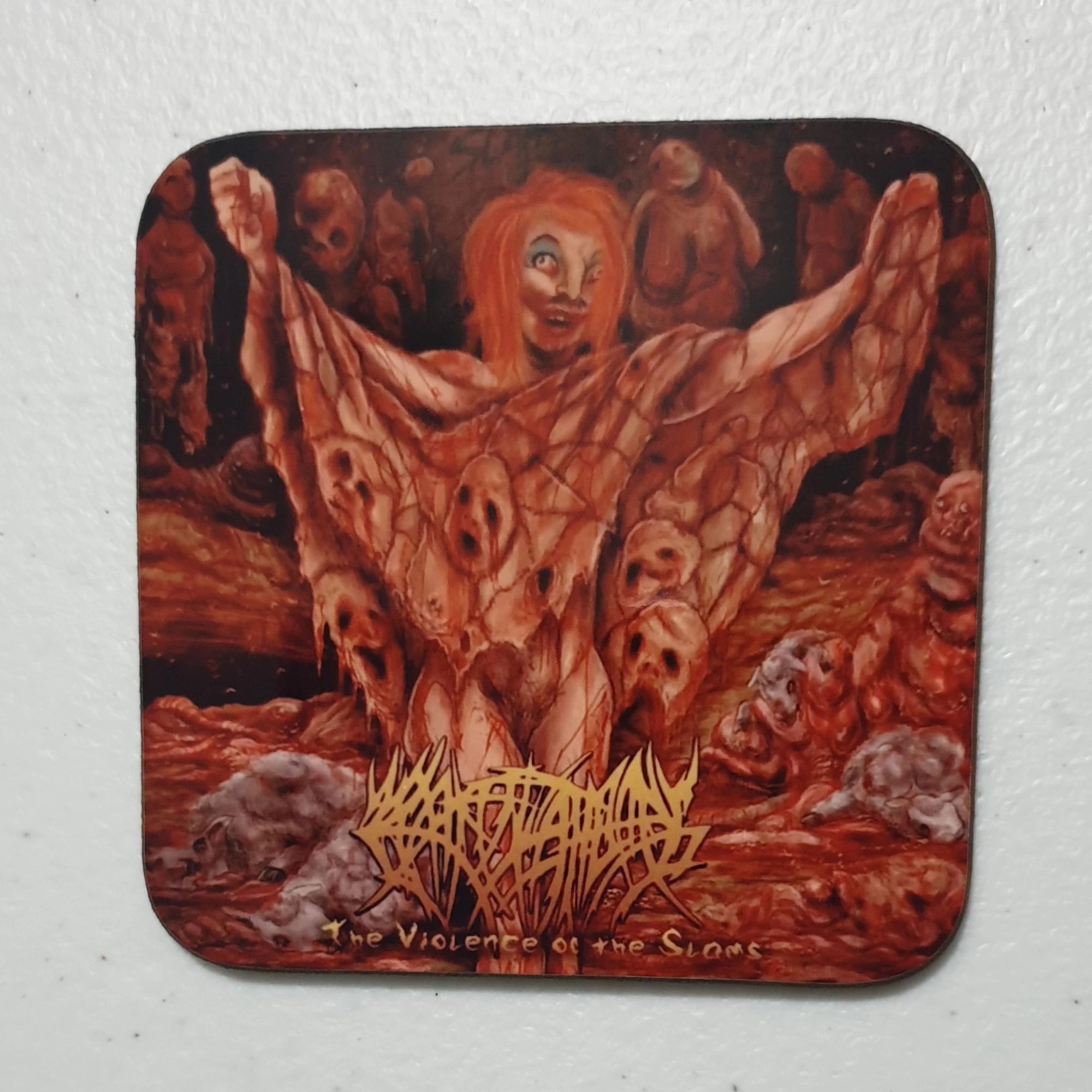 Coaster with a graphic design of a woman with red hair and winged creature, surrounded by other figures, on a white background.