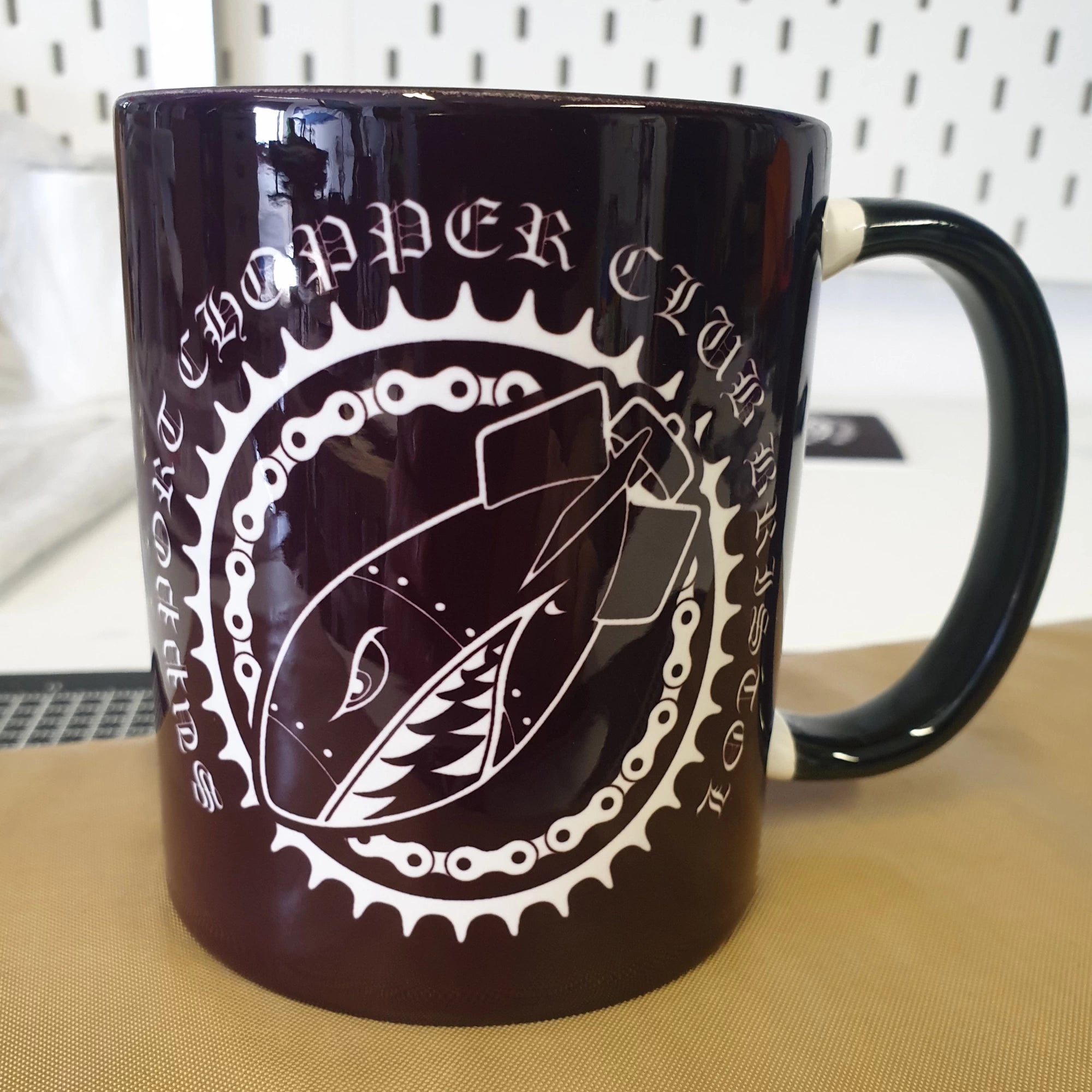 Black mug with white graphic design on a wooden surface