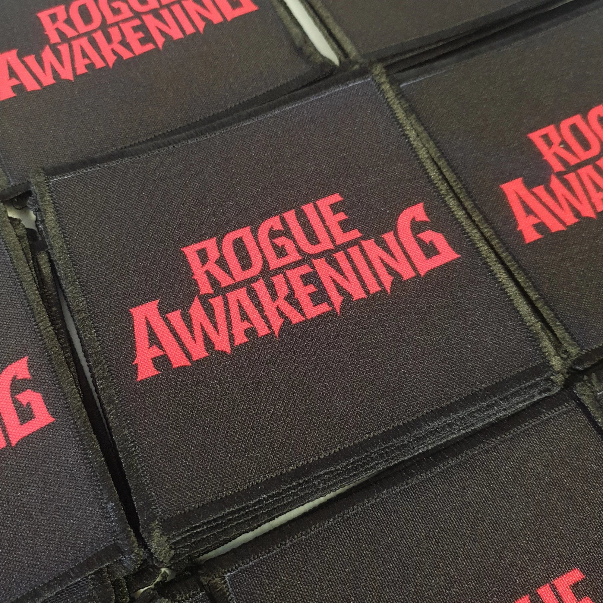 Black patches with 'Rogue Awakening' text in red arranged in a pattern.