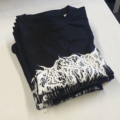 Stack of black band t-shirts with white graphic design on a white surface
