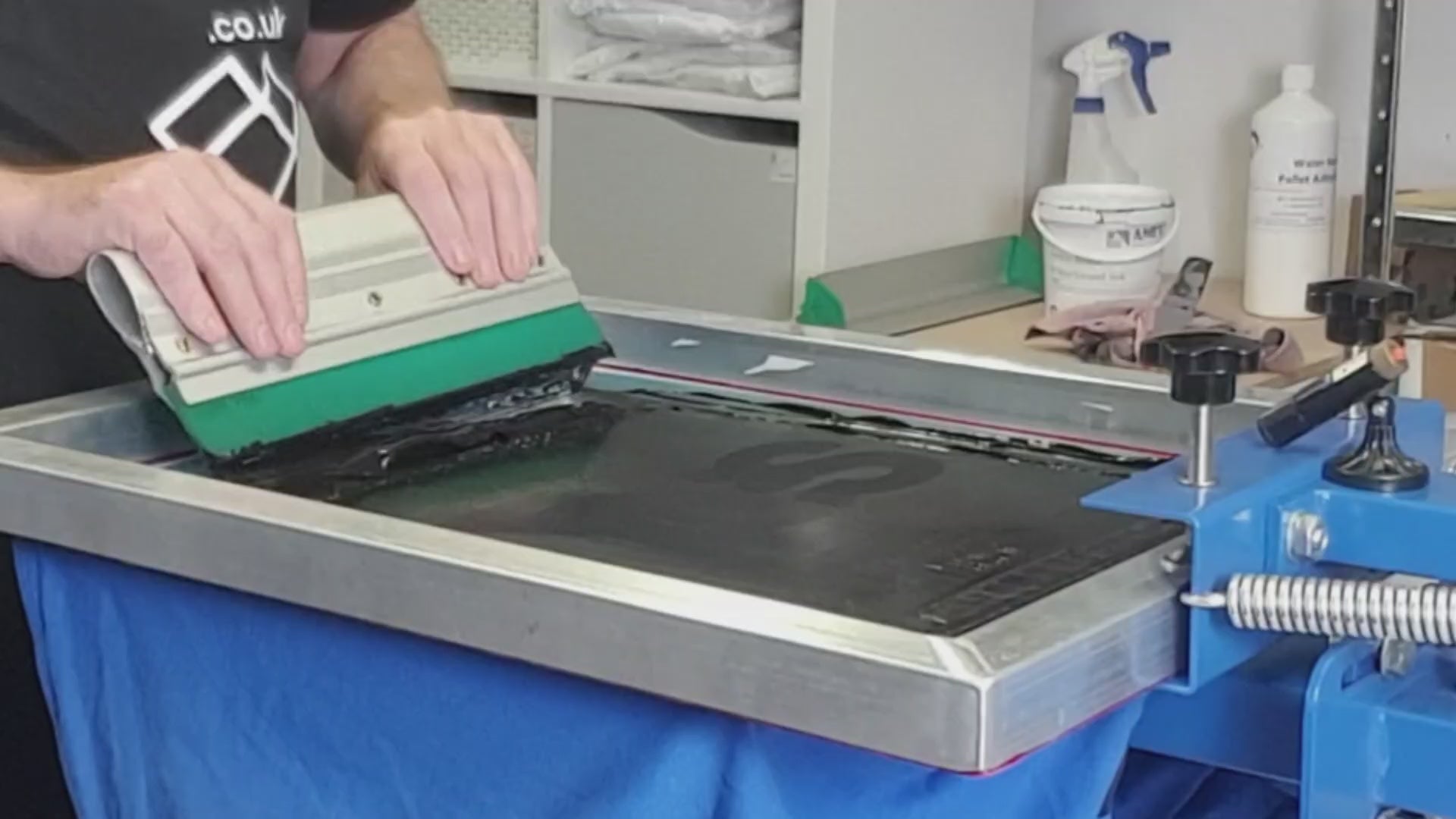 Load video: Screen printing a t-shirt on a manual screen press