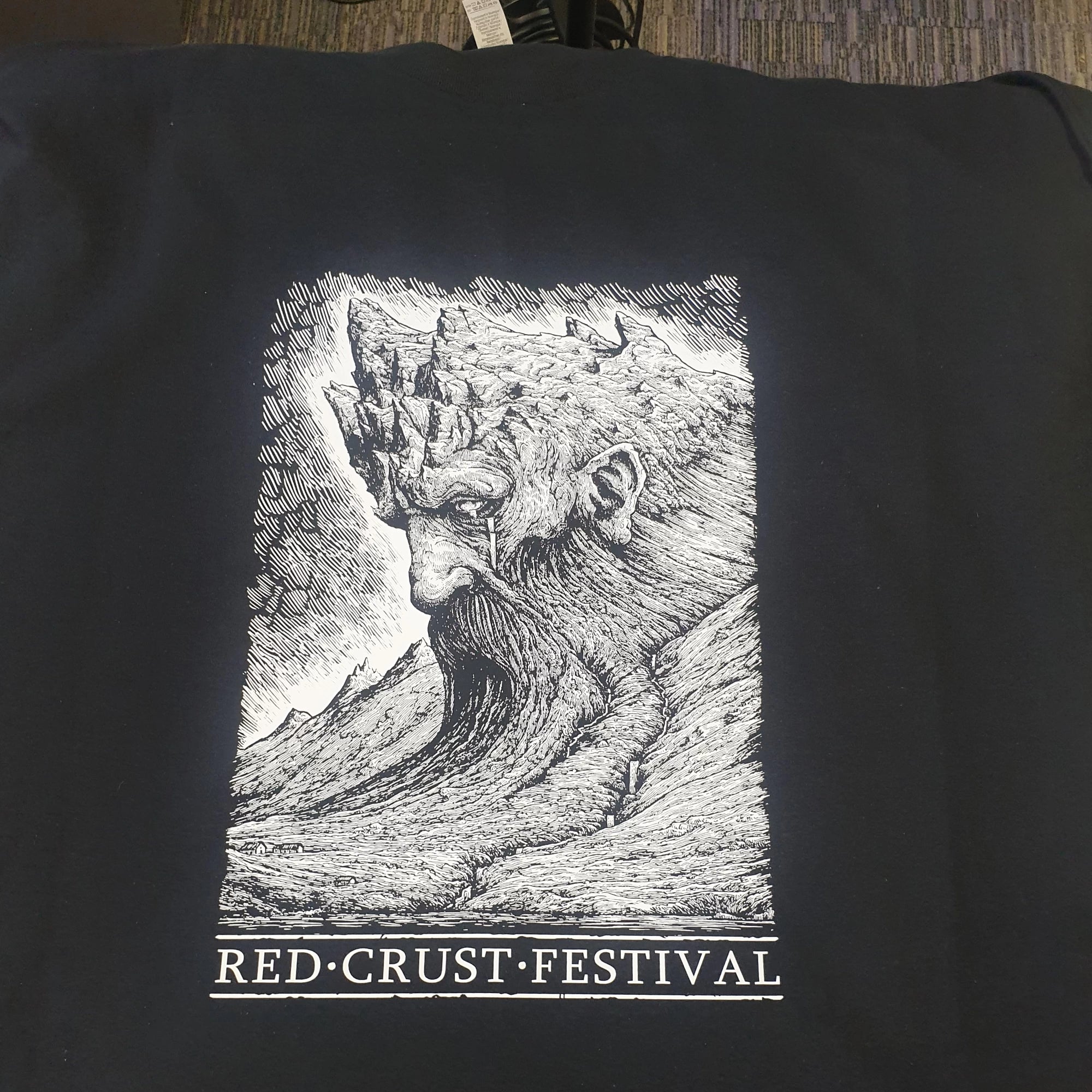 Black t-shirt with a graphic of a bearded figure and 'Red Crust Festival' text on a plain background